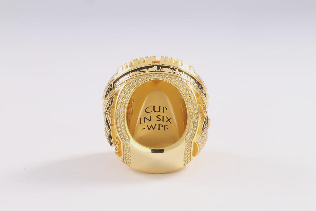 Gold ring with engraved text on a white background