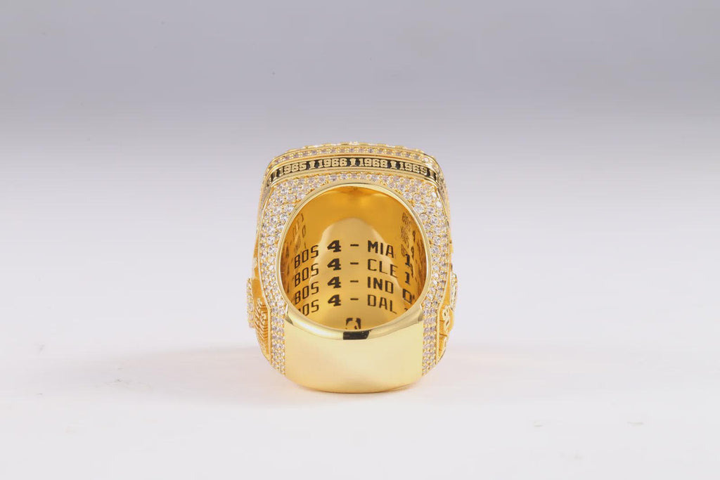 Gold ring with engraved text on a light gray background