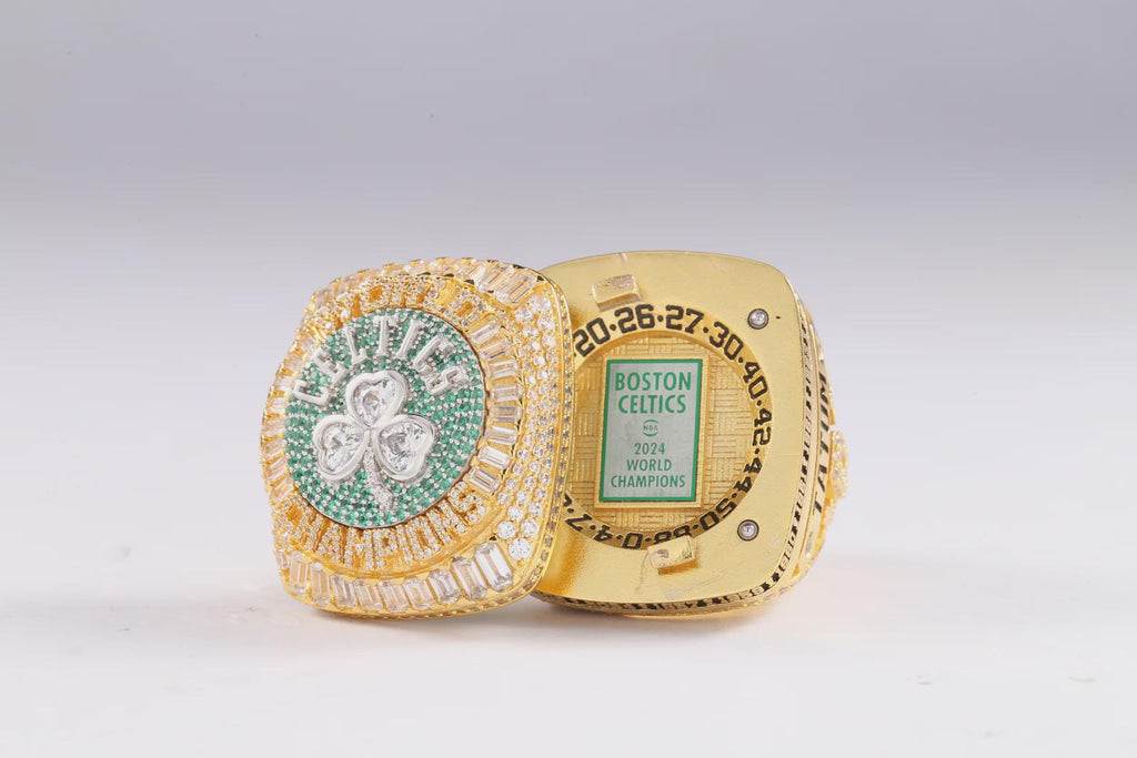 Gold championship ring with green gemstone on a white background
