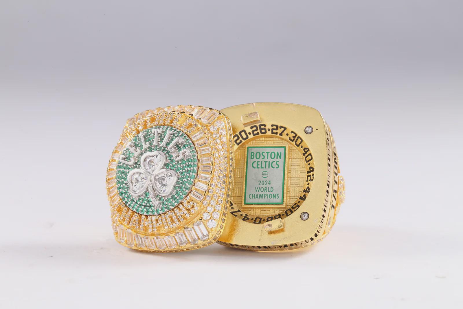 Gold championship ring with green gemstone on a white background