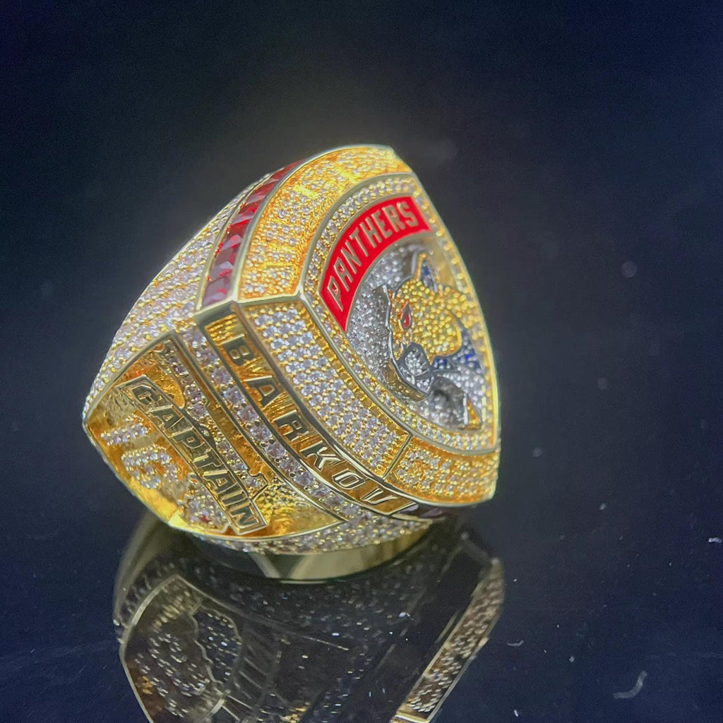 Gold championship ring with 'Panthers' text on a dark background