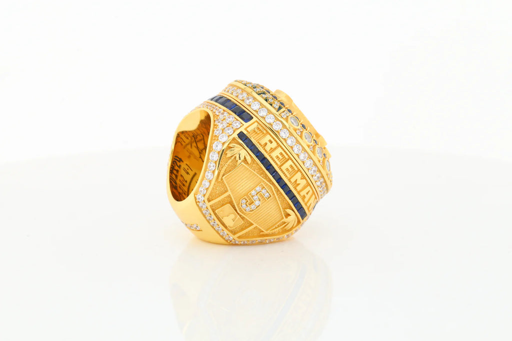 Gold ring with blue accents on a white background