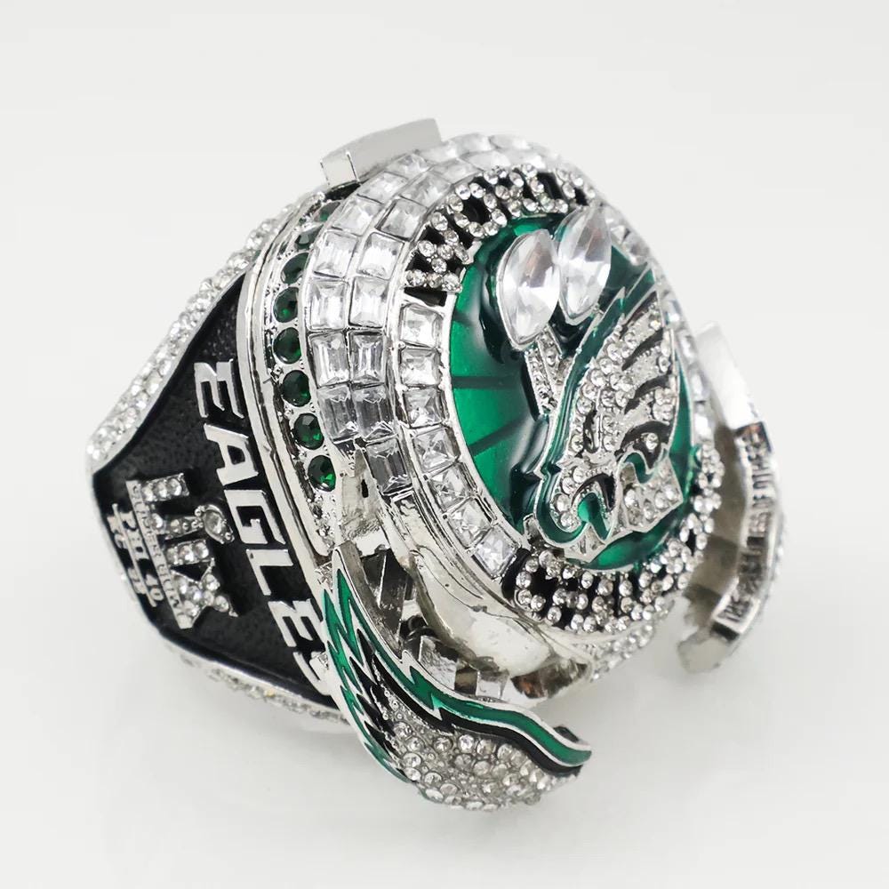 Decorative ring with green and silver design on a white background