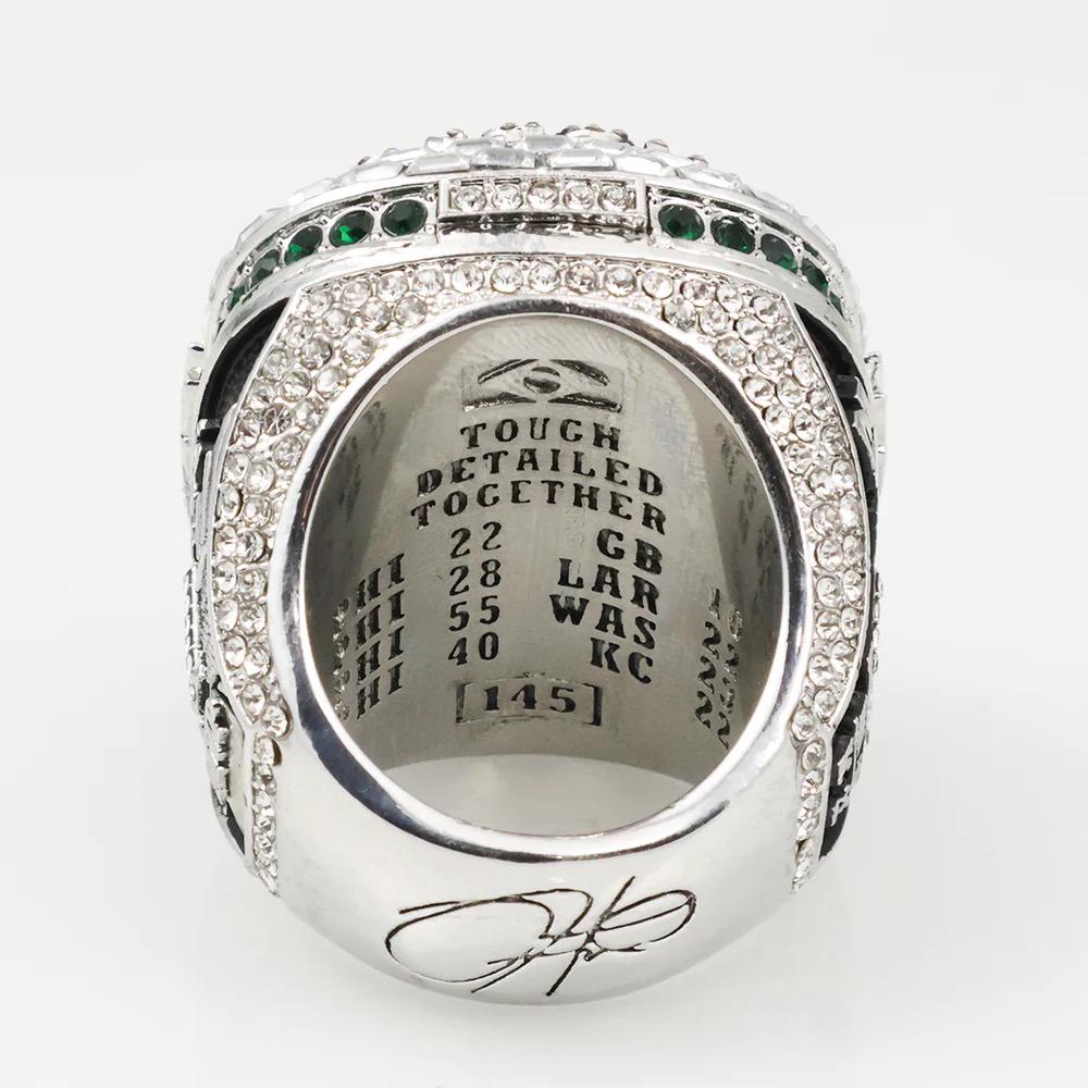 Silver ring with engraved text and design on a white background