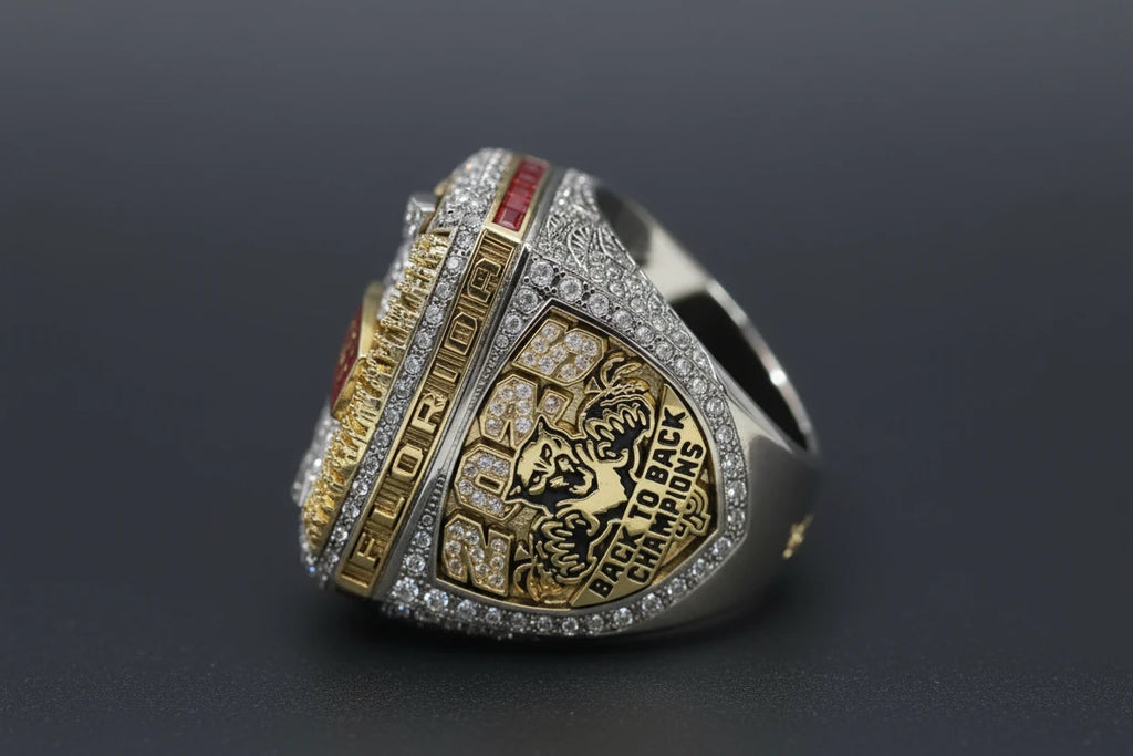 Silver and gold championship ring with engraved text on a textured surface